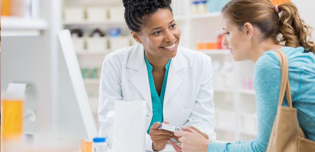 A pharmacist discusses a medication with a customer.