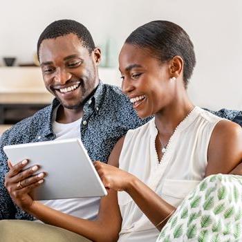 一对快乐的夫妇用他们的平板电脑查看他们在Patelco Online上的健康储蓄账户.